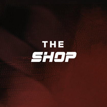 Red and black background with a faint racing flag with the words The Shop overlaid.